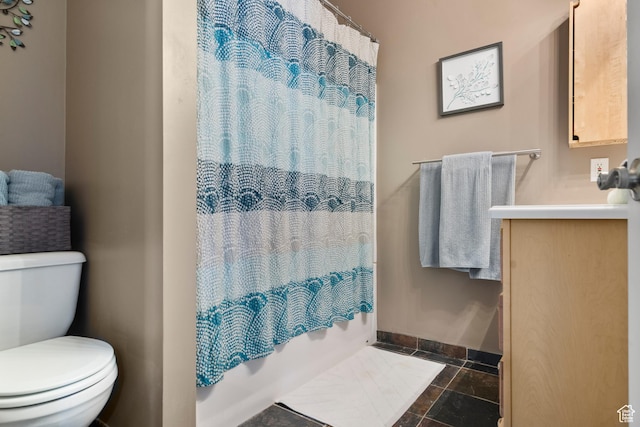 2456 E Bonneville Ter, South Ogden, UT 84403 - full bath featuring toilet, baseboards, stone tile floors, vanity, and shower / bath combo with shower curtain
