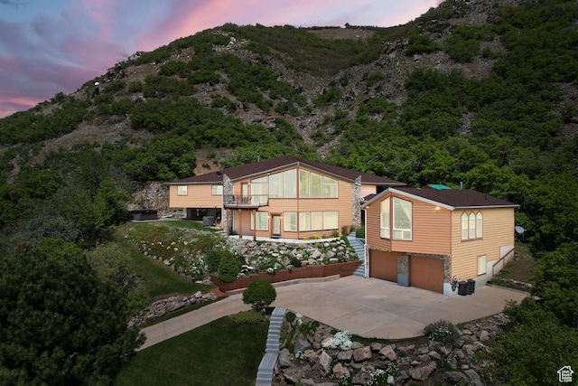 2456 E Bonneville Ter, South Ogden, UT 84403 - back of house at dusk featuring concrete driveway, an attached garage, and a mountain view