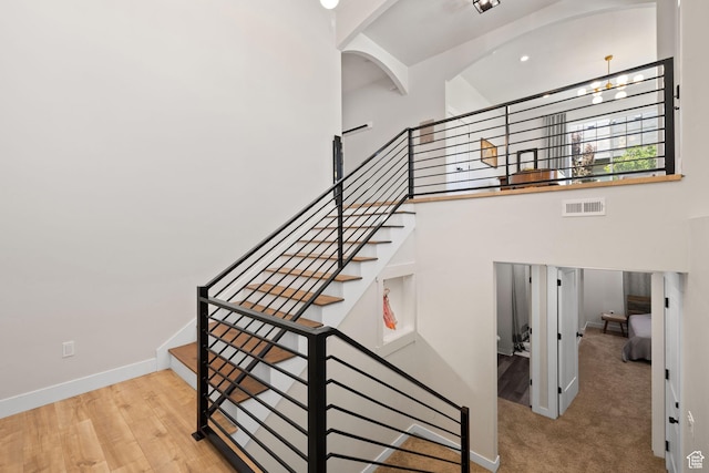 stairway with baseboards and a towering ceiling
