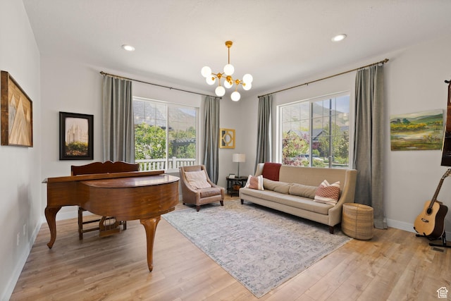 living area featuring a chandelier, light wood-type flooring, baseboards, and recessed lighting