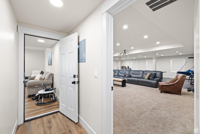 corridor with baseboards, recessed lighting, wood finished floors, and electric panel