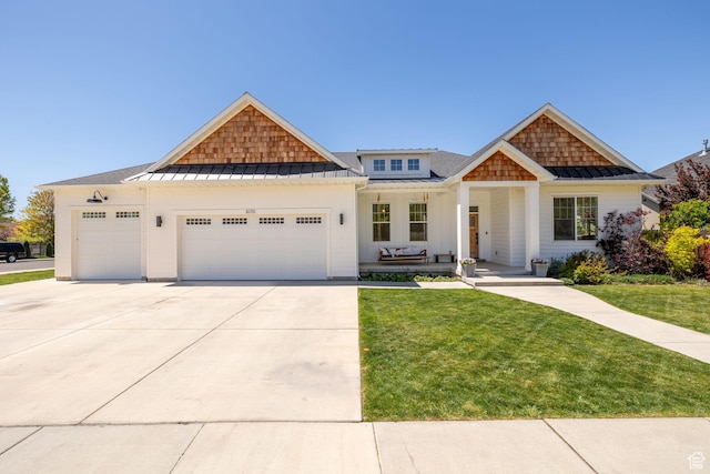 craftsman-style home featuring a standing seam roof, an attached garage, and a front lawn