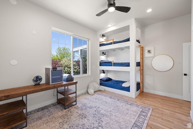 bedroom with baseboards, wood finished floors, a ceiling fan, an office area, and recessed lighting