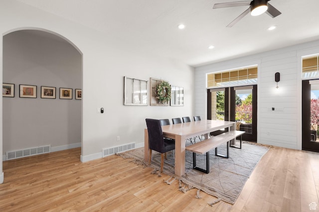 dining room with arched walkways, light wood finished floors, recessed lighting, a ceiling fan, and baseboards