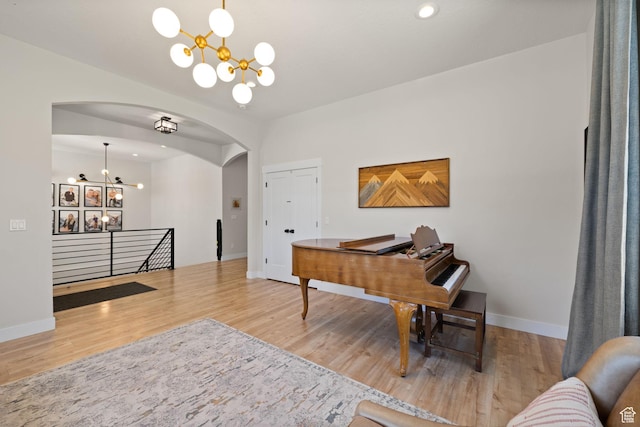 home office with a chandelier, arched walkways, wood finished floors, baseboards, and recessed lighting