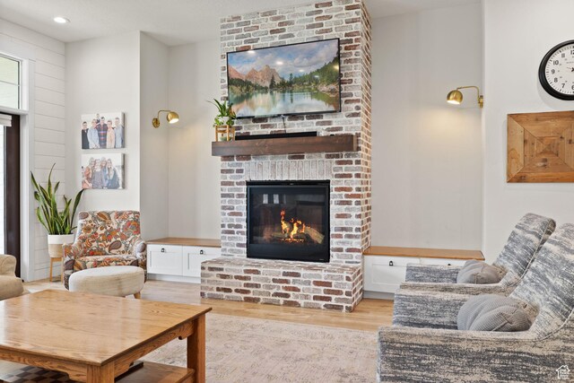 living area with wood finished floors, a fireplace, and recessed lighting