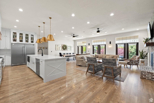 kitchen featuring appliances with stainless steel finishes, recessed lighting, ceiling fan, open floor plan, and light countertops