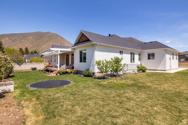 rear view of property with a deck with mountain view and roof with shingles
