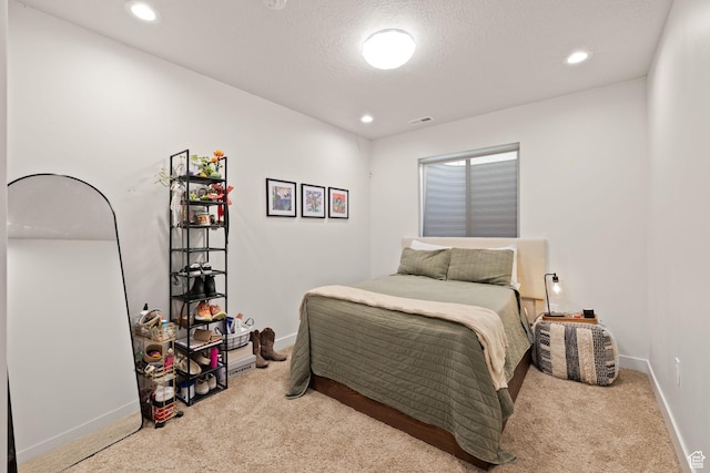 carpeted bedroom featuring baseboards, recessed lighting, and a textured ceiling