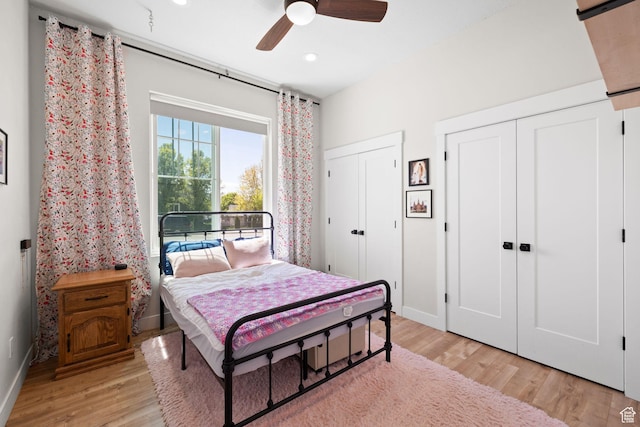 bedroom with multiple closets, light wood finished floors, baseboards, recessed lighting, and a ceiling fan