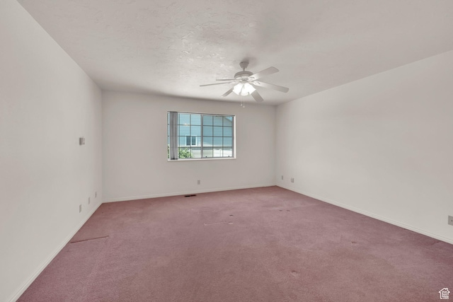 unfurnished room featuring light colored carpet, a ceiling fan, and baseboards