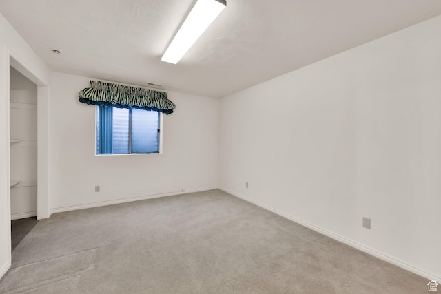 unfurnished room with carpet and baseboards