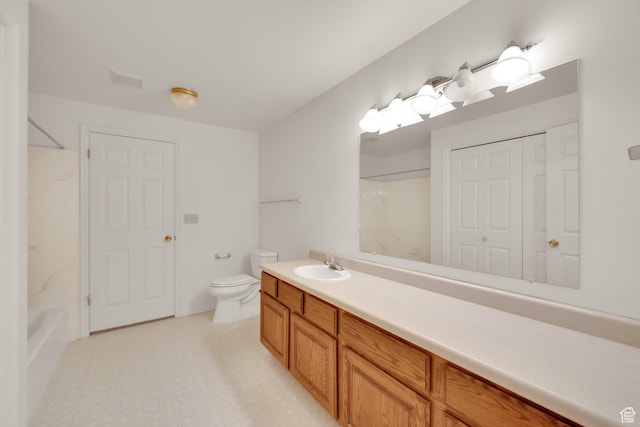 bathroom featuring toilet, vanity, and shower / bathtub combination