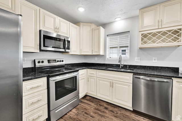 256 13th St, Ogden, UT 84404 - kitchen featuring stainless steel appliances, a sink, dark wood-style flooring, cream cabinets, and a textured ceiling