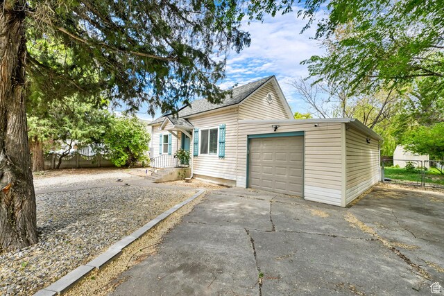 256 13th St, Ogden, UT 84404 - view of front of house featuring concrete driveway, fence, and a garage
