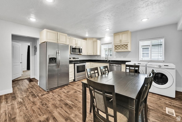 256 13th St, Ogden, UT 84404 - kitchen featuring appliances with stainless steel finishes, washer / clothes dryer, cream cabinets, dark wood-type flooring, and a textured ceiling