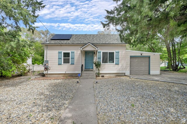 256 13th St, Ogden, UT 84404 - bungalow-style home featuring a garage, roof mounted solar panels, driveway, and a shingled roof