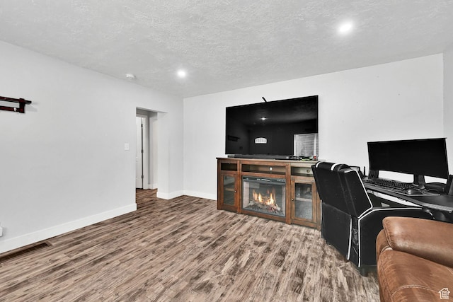 256 13th St, Ogden, UT 84404 - living area featuring wood finished floors, baseboards, a textured ceiling, and a glass covered fireplace