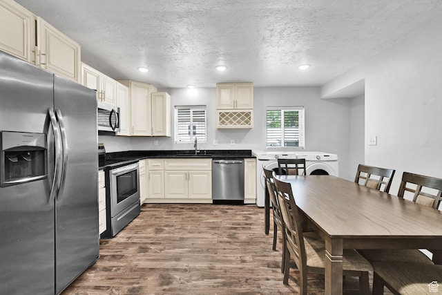256 13th St, Ogden, UT 84404 - kitchen featuring stainless steel appliances, dark wood-style flooring, a sink, a textured ceiling, and dark countertops