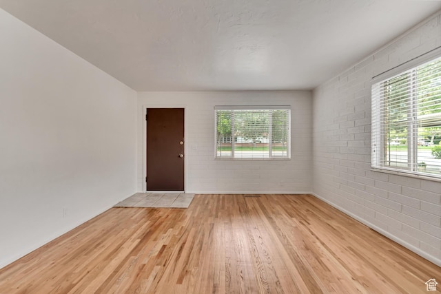 3400 S 2000 E, Millcreek, UT 84109 - empty room featuring light wood-type flooring, brick wall, and baseboards
