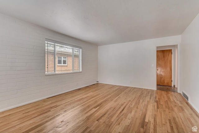 3400 S 2000 E, Millcreek, UT 84109 - empty room featuring wood finished floors, baseboards, and brick wall
