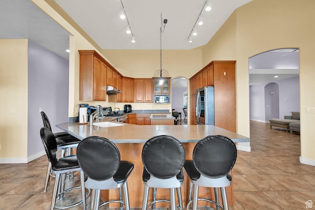 337 S 300 E, Willard, UT 84340 - kitchen with stainless steel appliances, arched walkways, a sink, under cabinet range hood, and a peninsula