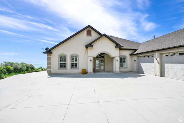 337 S 300 E, Willard, UT 84340 - view of front facade with french doors, stucco siding, a garage, concrete driveway, and a shingled roof