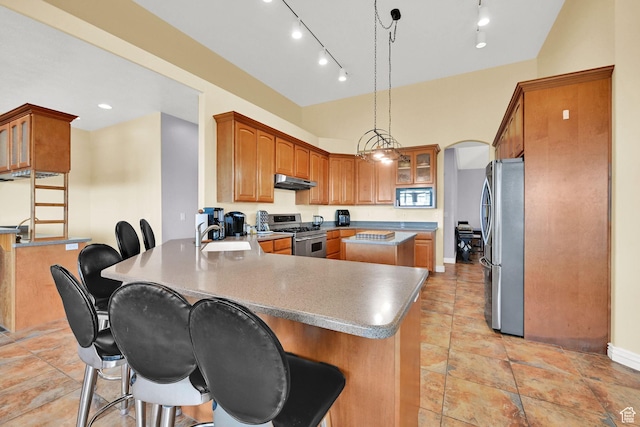 337 S 300 E, Willard, UT 84340 - kitchen with stainless steel appliances, under cabinet range hood, a peninsula, a sink, and a breakfast bar