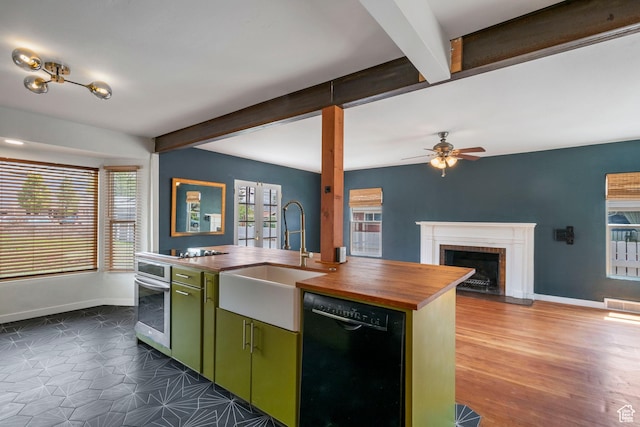 kitchen featuring dishwasher, wood counters, green cabinetry, oven, and a sink