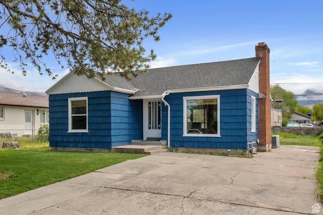 view of front of home featuring a chimney and roof with shingles