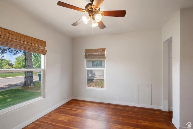 empty room with wood finished floors, baseboards, and a ceiling fan