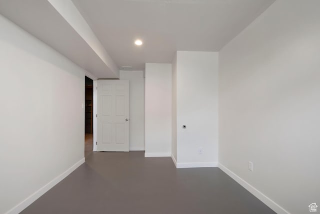 spare room featuring concrete floors, baseboards, and recessed lighting