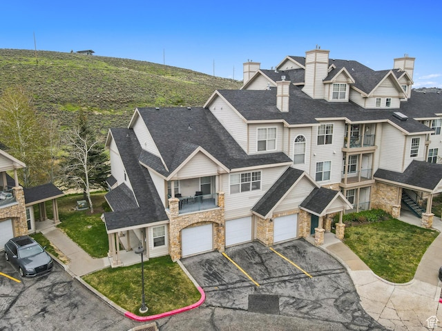 900 Bitner Rd Unit D11, Park City, UT 84098 - view of front of house featuring stone siding, driveway, a garage, a balcony, and roof with shingles