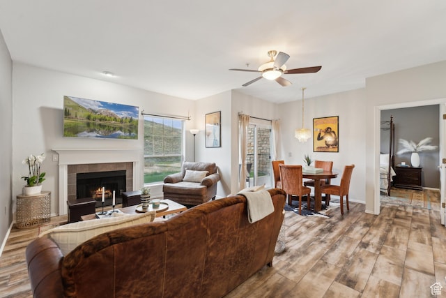 900 Bitner Rd Unit D11, Park City, UT 84098 - living room featuring wood finished floors, a ceiling fan, a tile fireplace, and baseboards