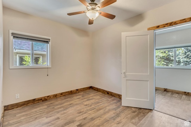 empty room with light wood-style floors, baseboards, and a ceiling fan