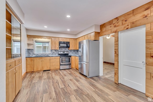kitchen with stainless steel appliances, a sink, light wood-style floors, backsplash, and light brown cabinets