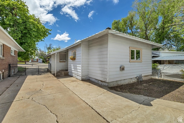 view of property exterior with fence and a gate
