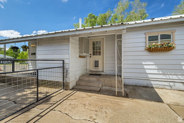property entrance featuring metal roof and fence