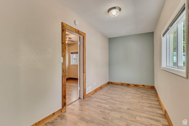 spare room featuring light wood-style floors, baseboards, and a smoke detector