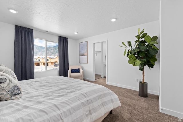 bedroom with a mountain view, carpet, recessed lighting, a textured ceiling, and baseboards