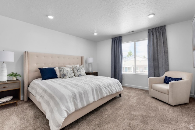 carpeted bedroom featuring a textured ceiling, recessed lighting, and baseboards