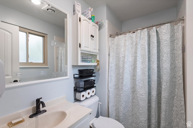 bathroom featuring toilet, vanity, and a shower with shower curtain