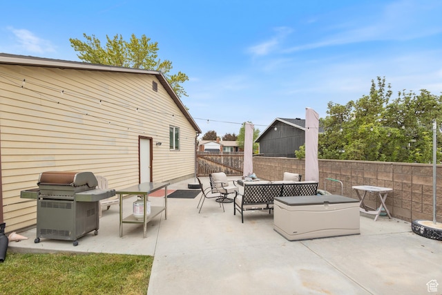 view of patio featuring a grill, fence, and an outdoor living space
