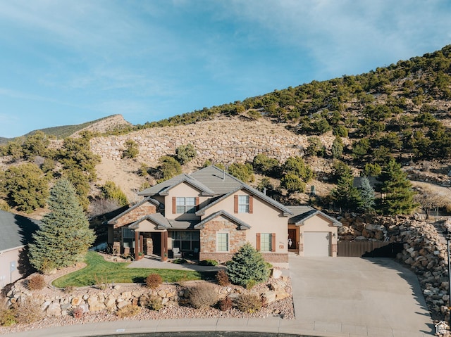 1866 N Matchstick Way, Cedar City, UT 84721 - view of front facade with driveway, stucco siding, stone siding, a mountain view, and fence