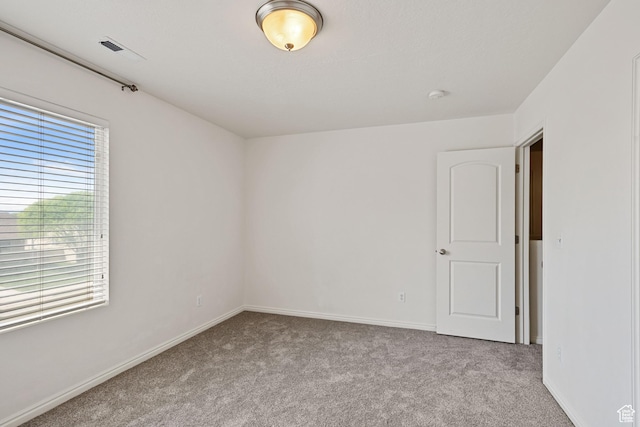 unfurnished room with carpet and baseboards