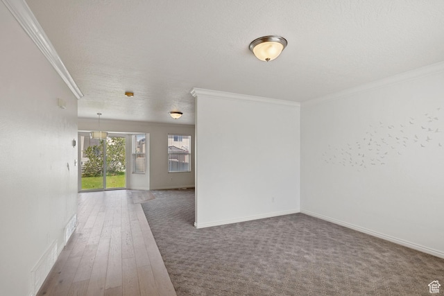 empty room featuring crown molding, baseboards, and wood finished floors