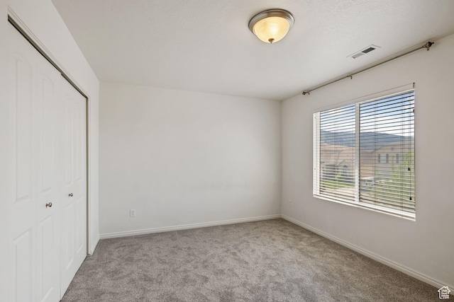 unfurnished bedroom with a closet, carpet flooring, and baseboards