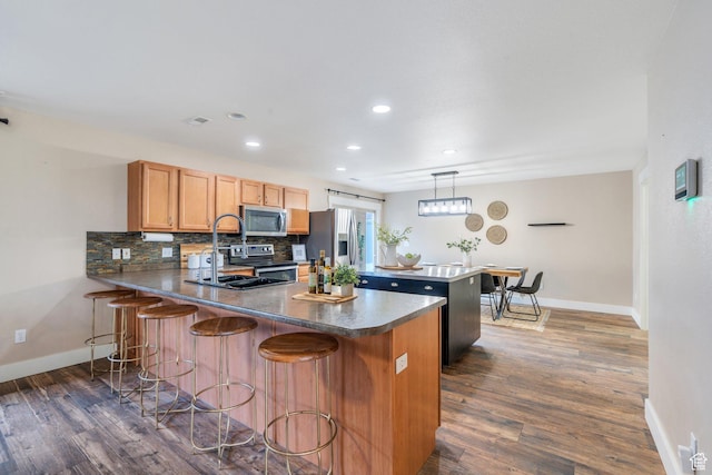 291 W Kestrel Dr, Saratoga Springs, UT 84045 - kitchen with appliances with stainless steel finishes, a peninsula, baseboards, dark wood-style floors, and recessed lighting