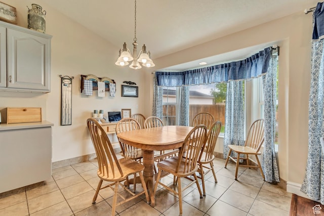 dining area with light tile patterned floors, a chandelier, and baseboards