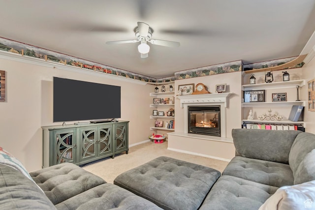 carpeted living room with a ceiling fan and a glass covered fireplace